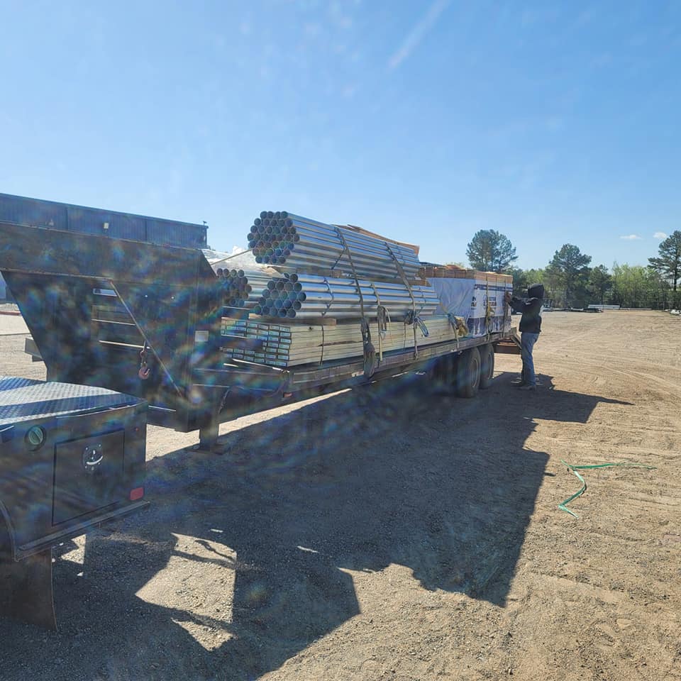 Galvanized fence pipe and posts loaded on trailer ready for install